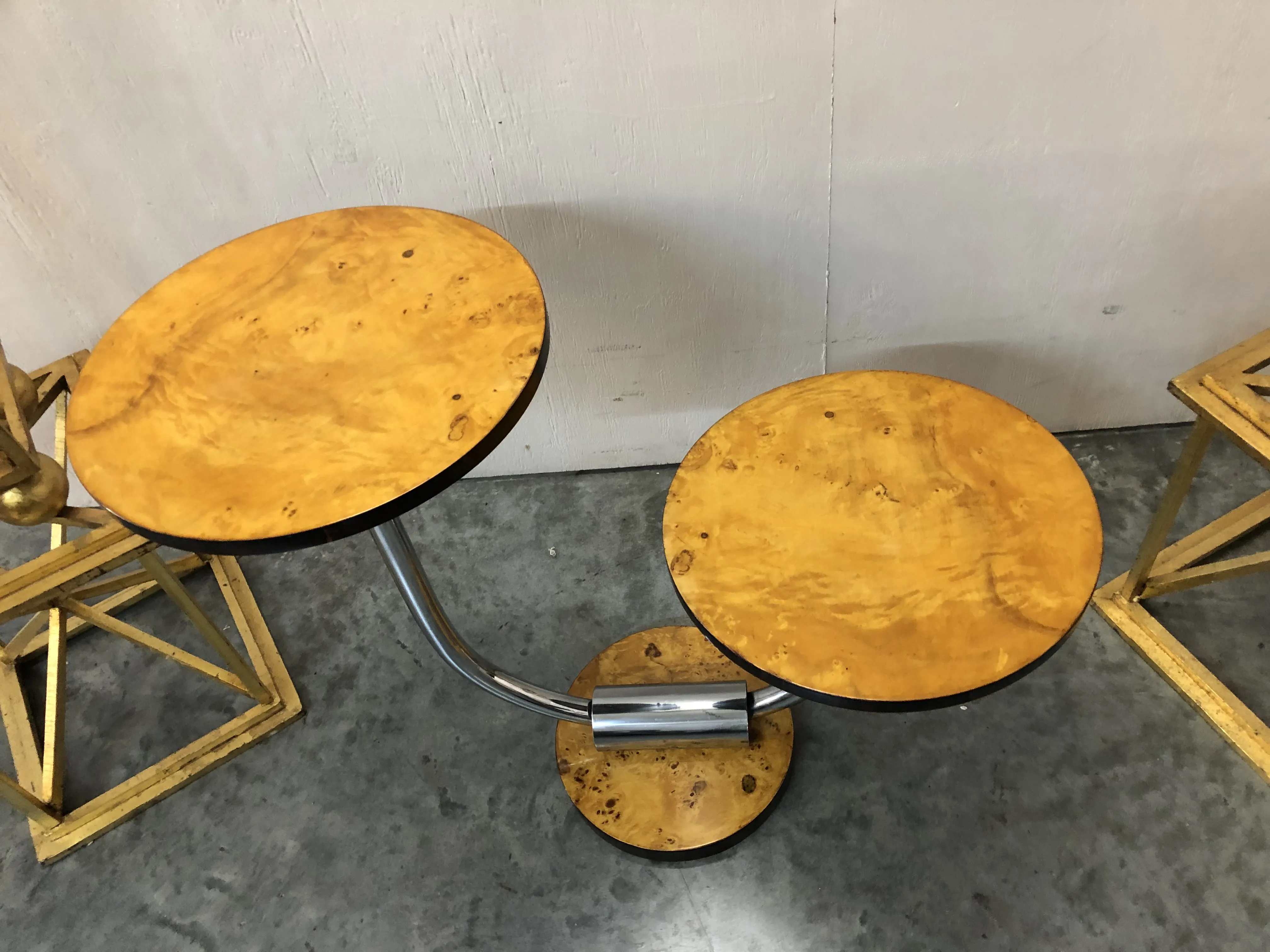 현대적 환경에 있는 금속 받침대가 있는 고대 둥근 테이블