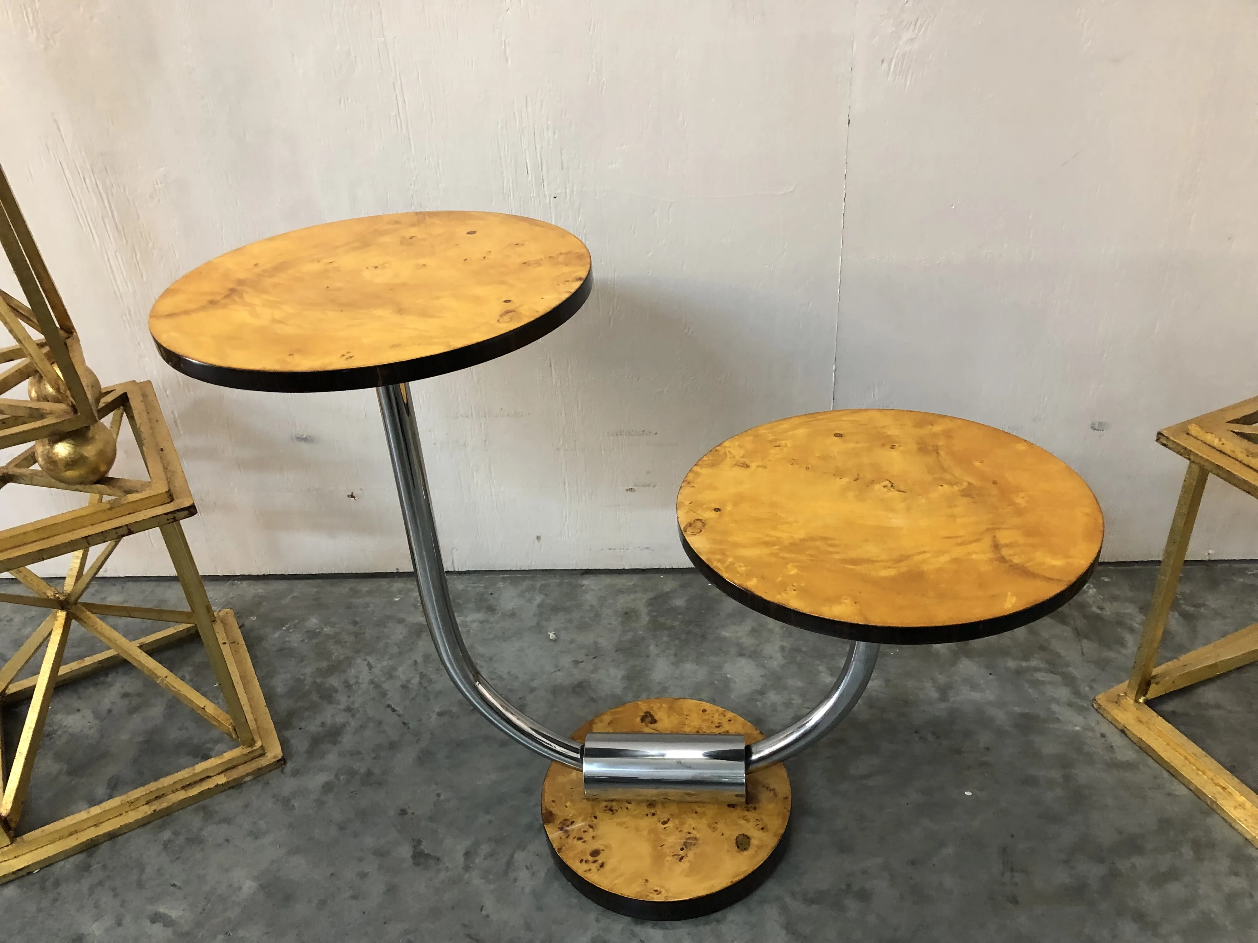 Tavolino antico a due livelli in un ambiente neutro, decorativo.