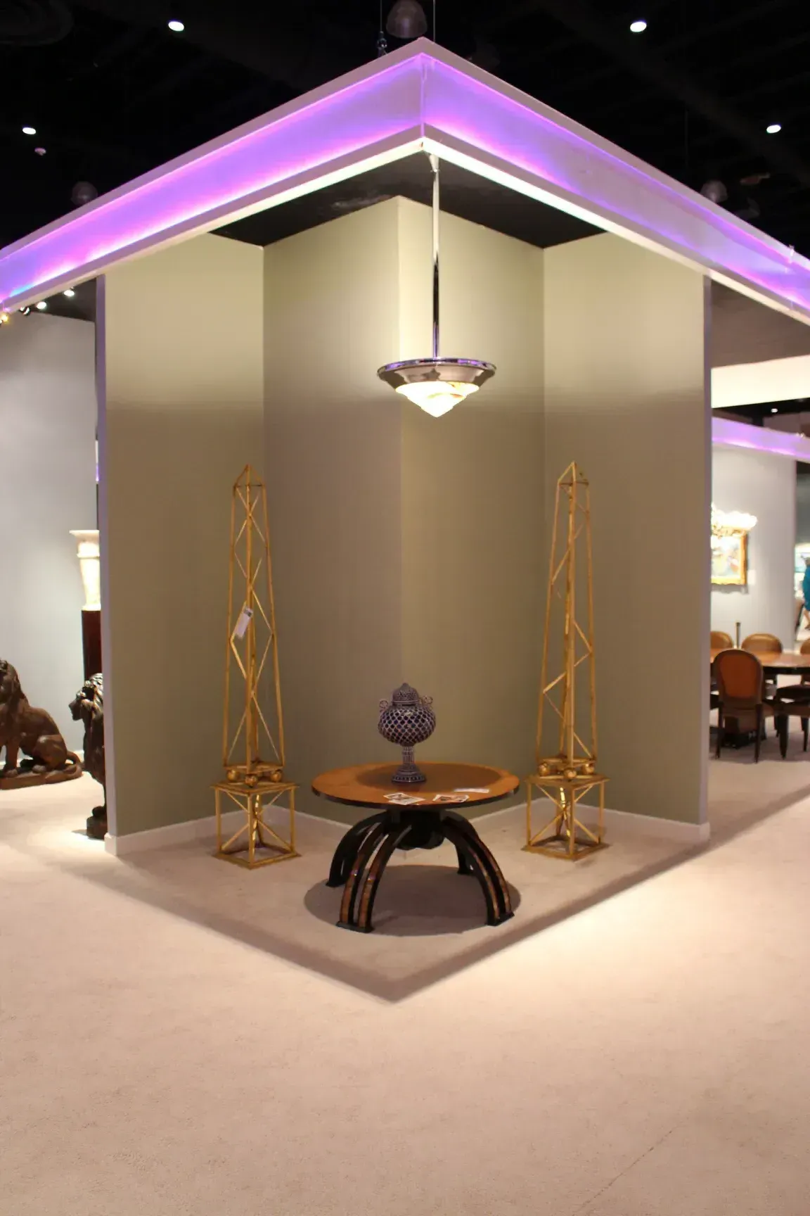 antique hanging lamp illuminating a space with tables and sculptures