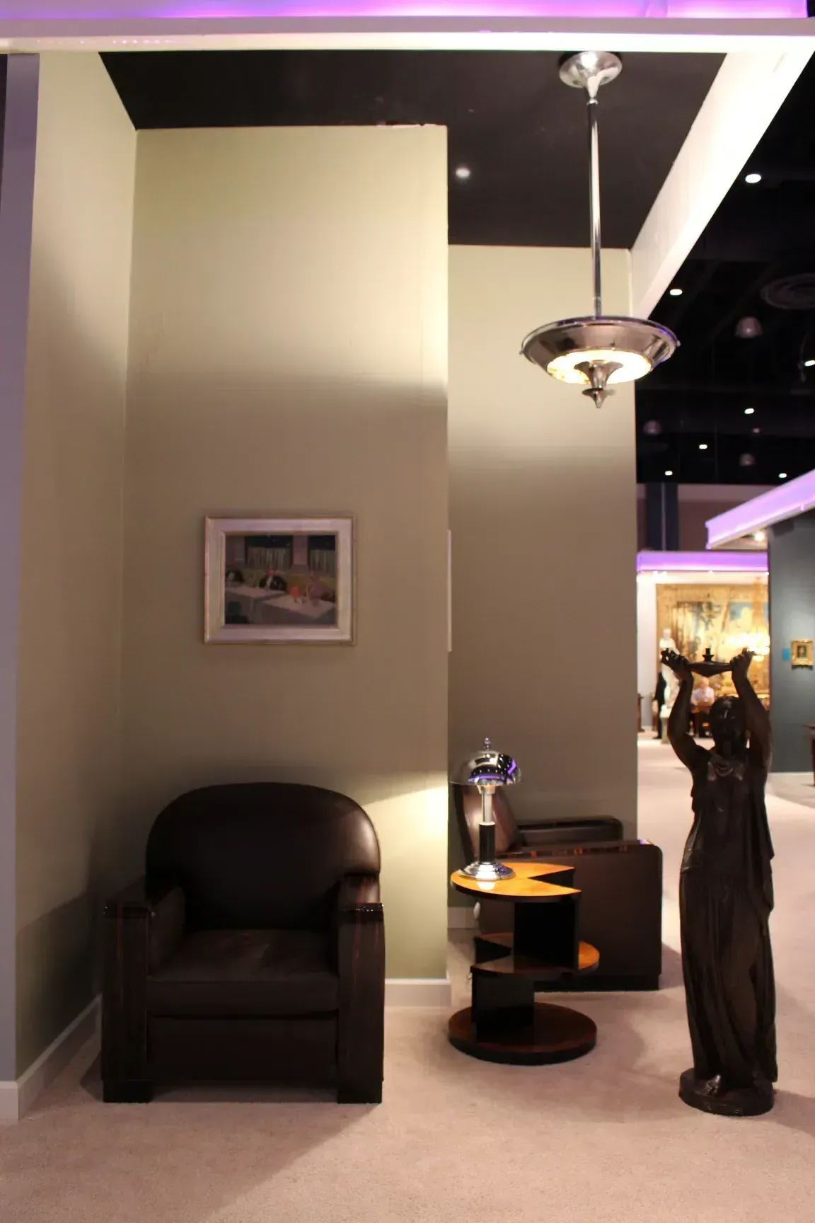 两盞古董吊燈在優雅的環境中，有一張扶手椅和一座雕塑。