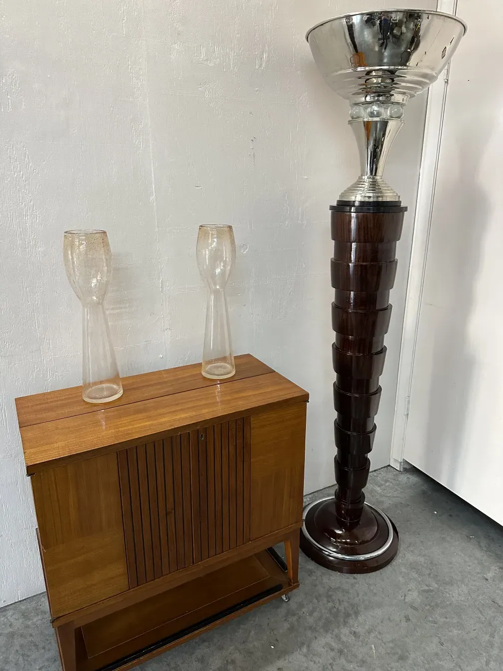 Two antique murano vases with decorative features in a cozy setting.