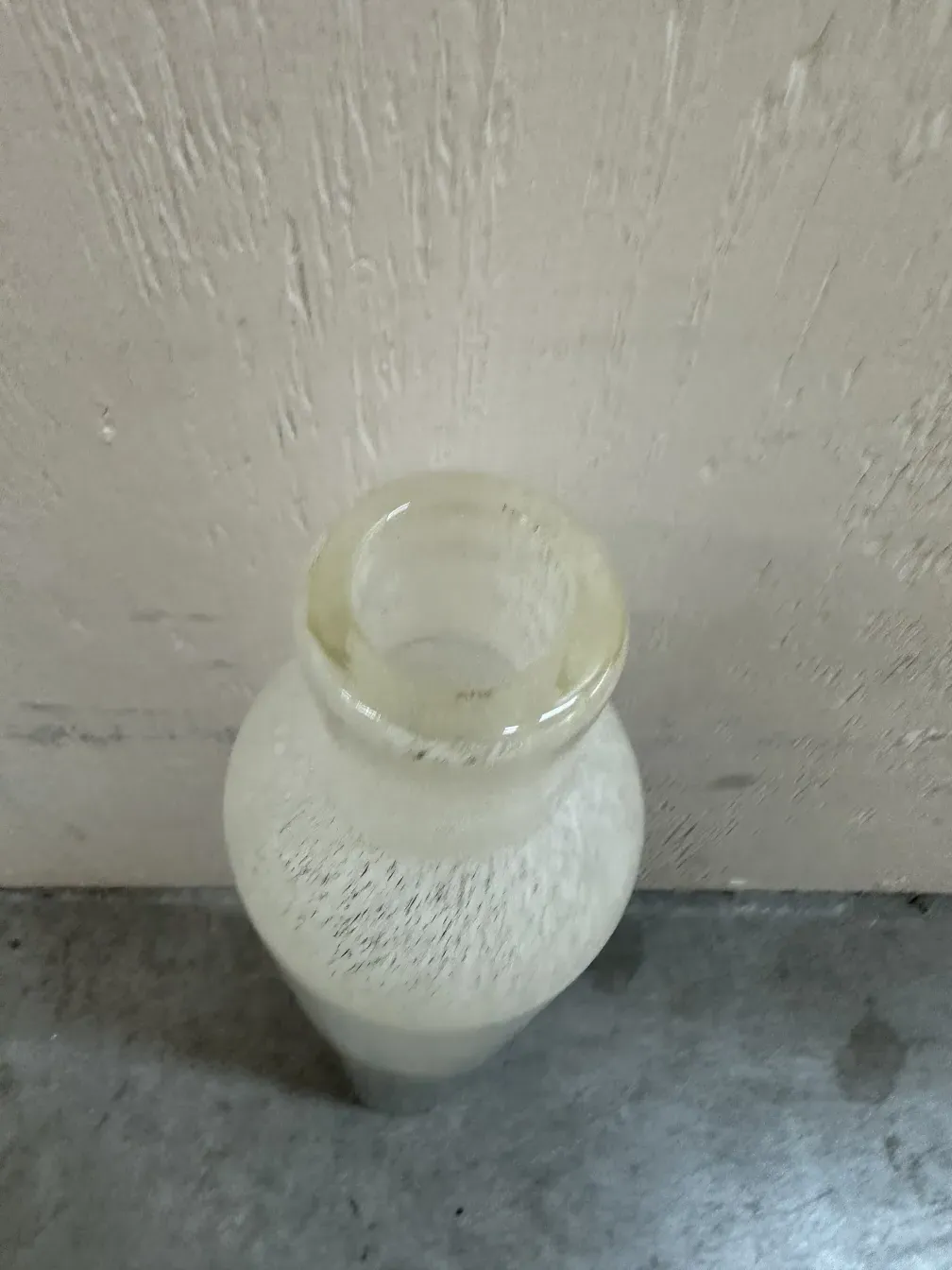 两个古董穆拉诺花瓶，形状优雅，一个更高。背景是木材和灰色墙壁。