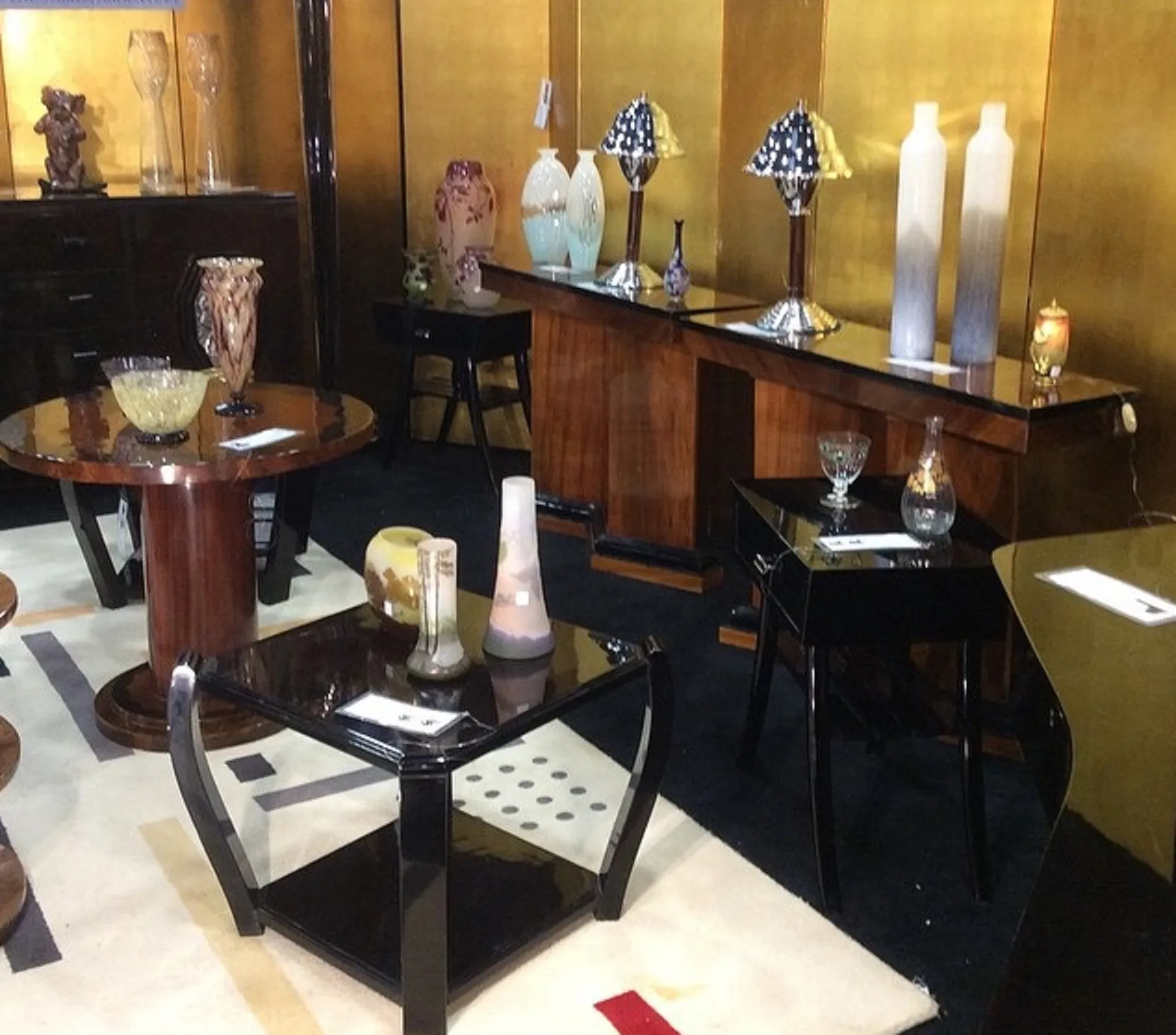 Dois vasos de Murano antigos em uma configuração de exibição com uma mesa e outros itens decorativos.