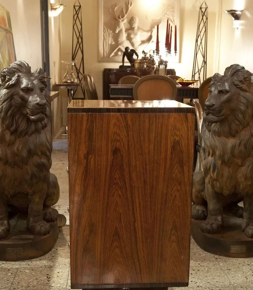 Antique cabinet with lions on either side, in an elegant setting.