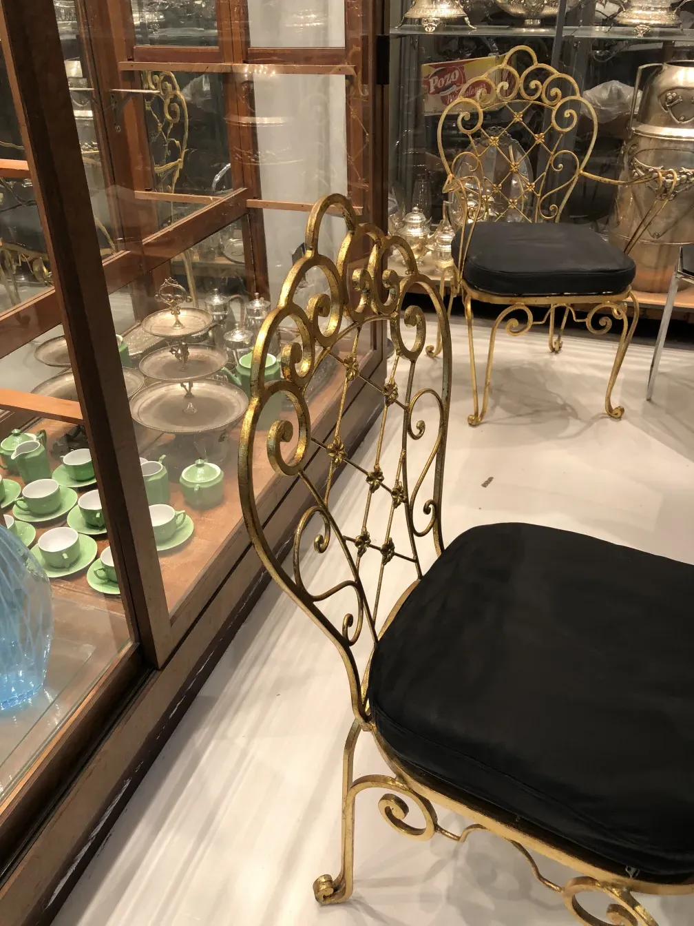 Conjunto de 2 sillas de jardín antiguas con diseño decorativo, en un ambiente elegante.