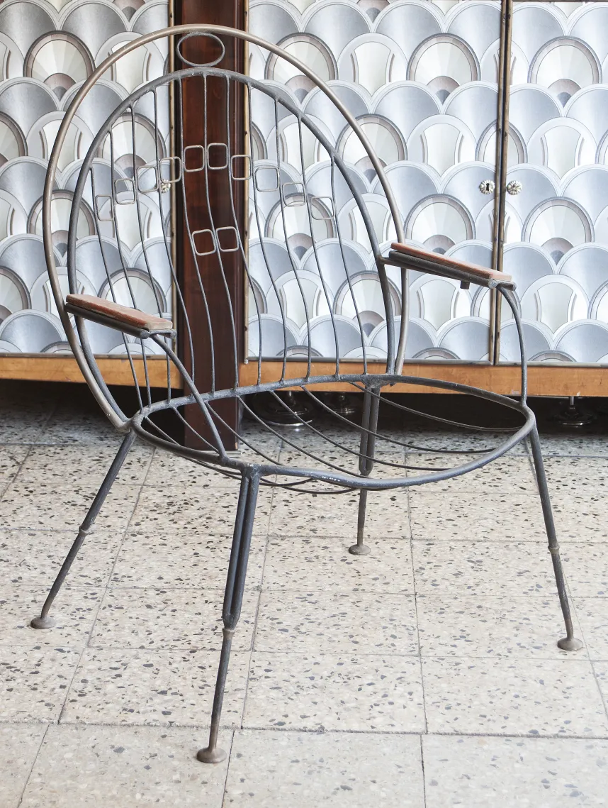 Antique garden armchair with arms, simple design, surrounded by a cozy environment.