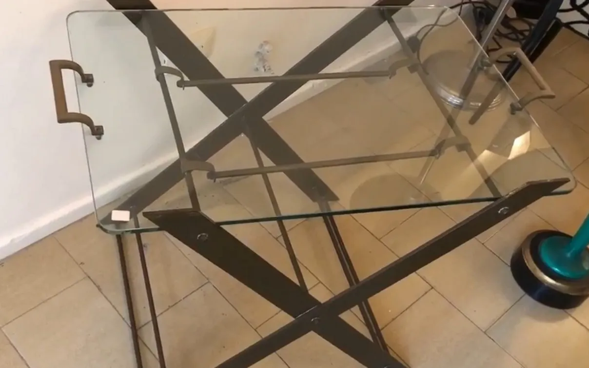 tavolino antico con piano in vetro e gambe eleganti in un ambiente accogliente