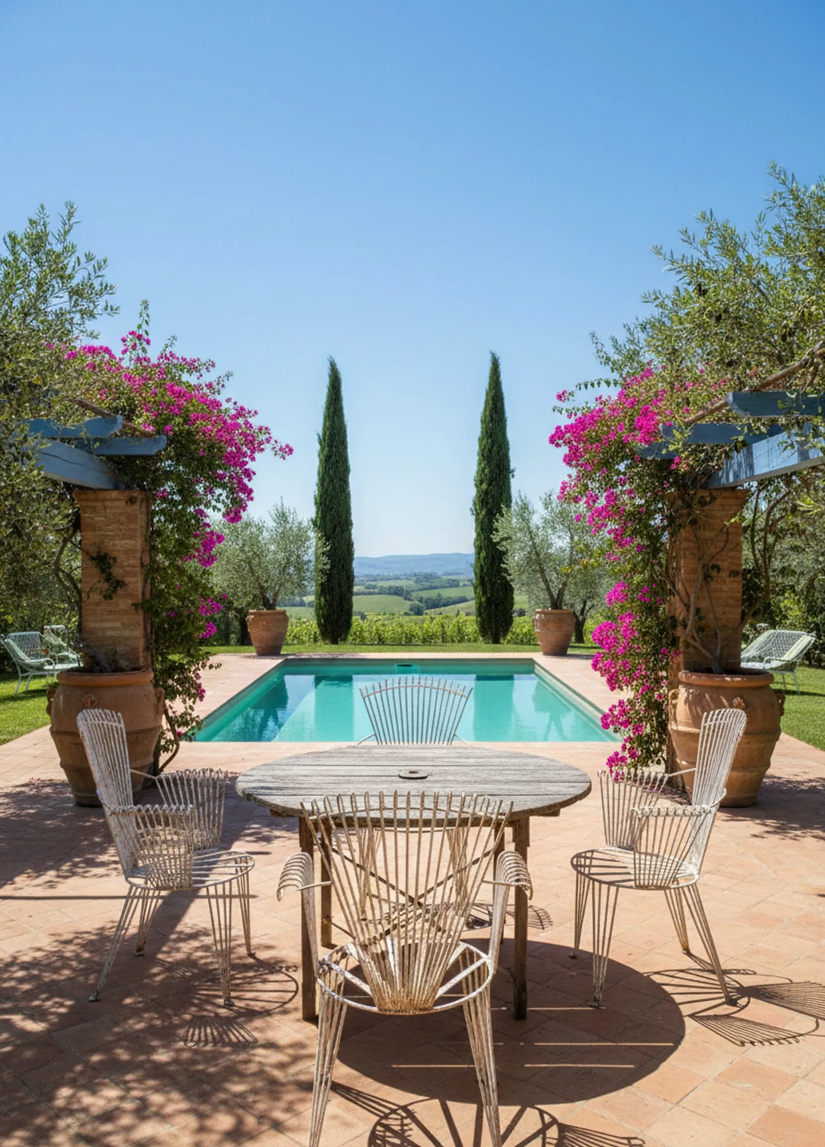 Four antique garden armchairs in a natural setting with flowers