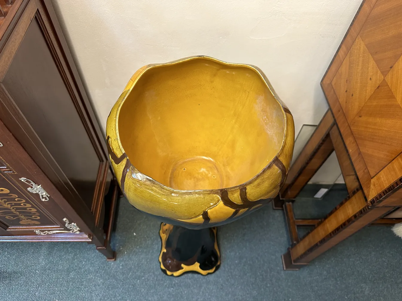 pot de fleurs ancien avec intérieur jaune et base décorative, entouré de meubles vintage