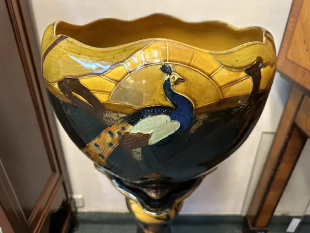 antique planter adorned with peacock design, vintage style