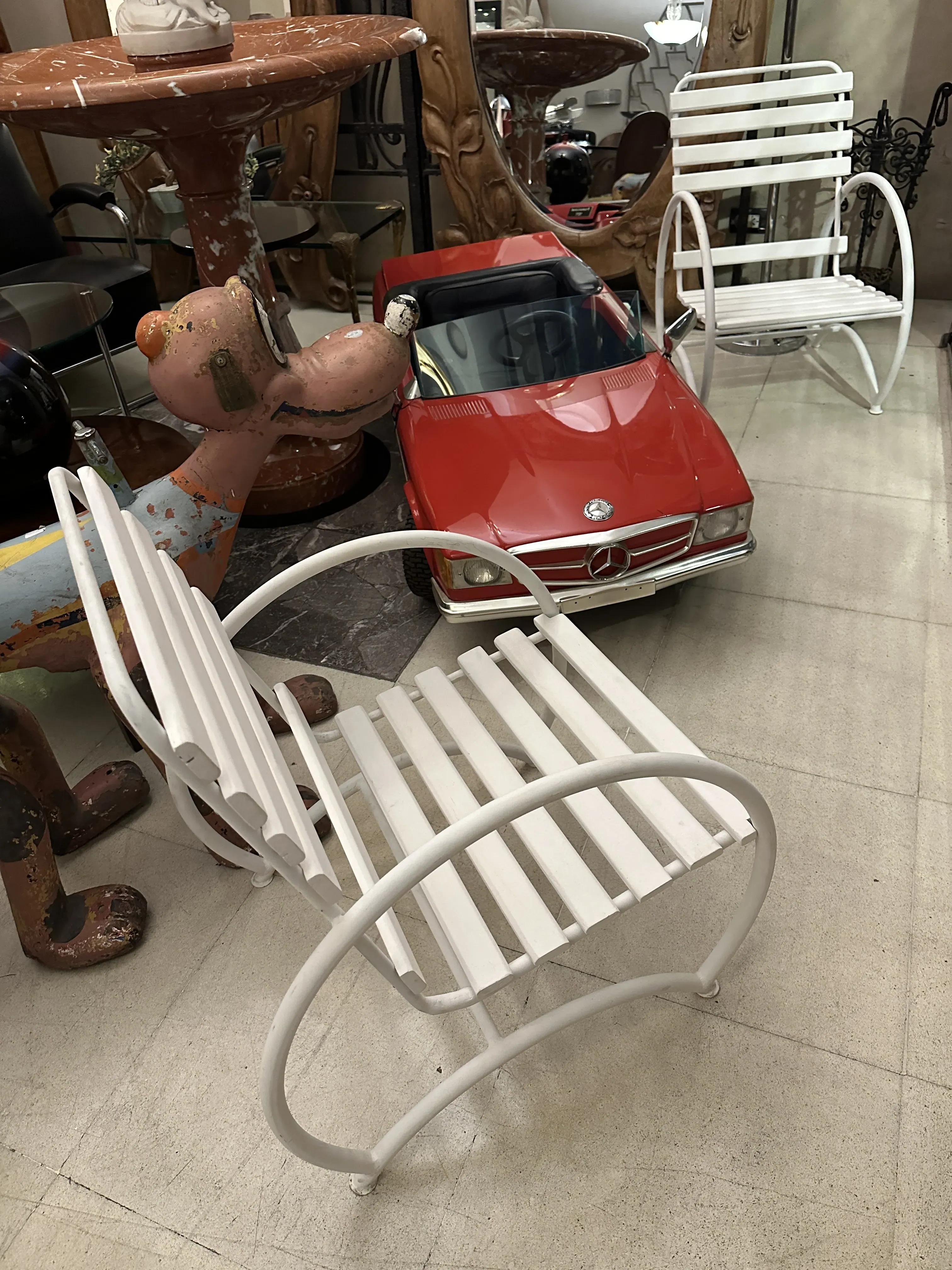 View of two antique white garden armchairs in a decorative setting