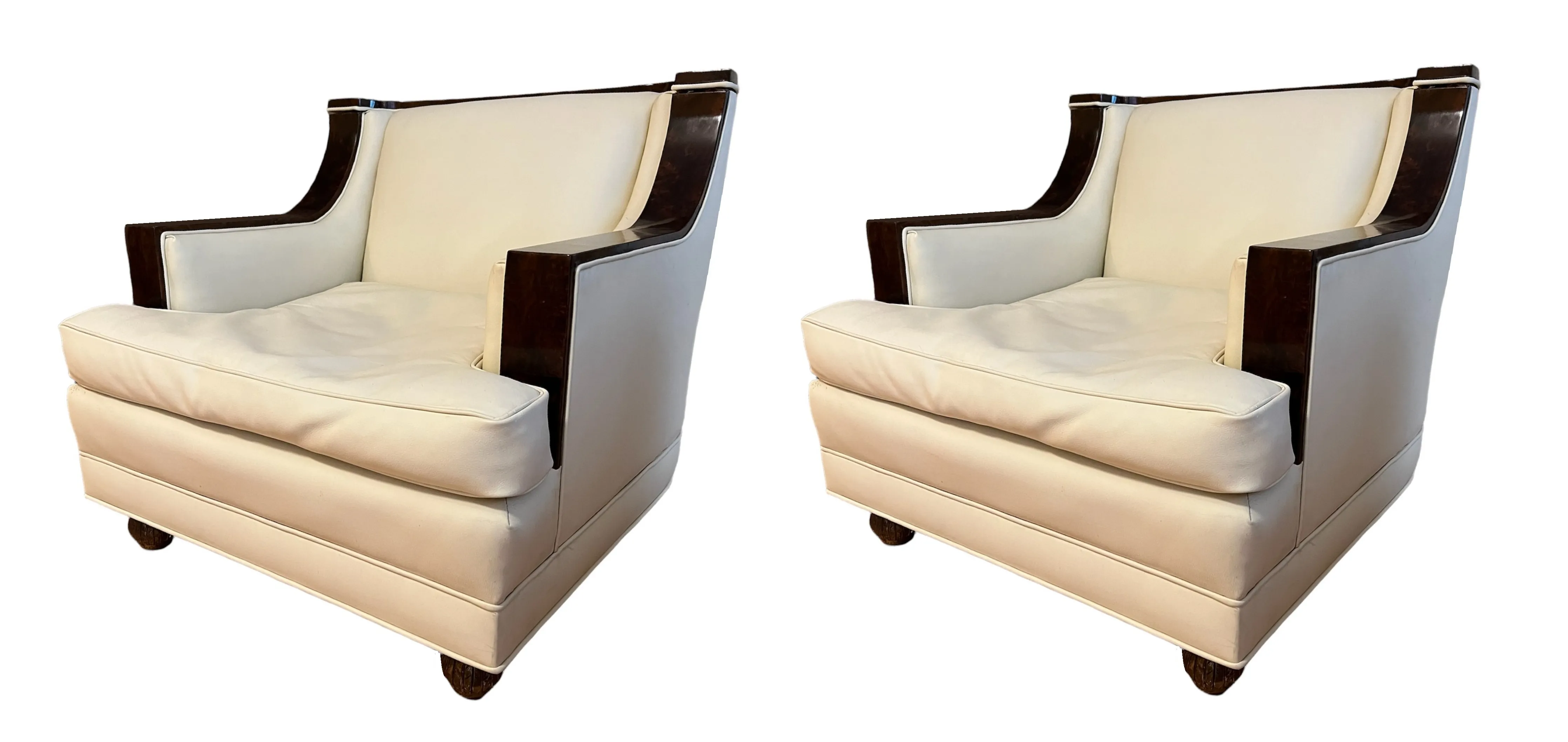 Dos sillones antiguos con brazos elegantes en un fondo neutro.