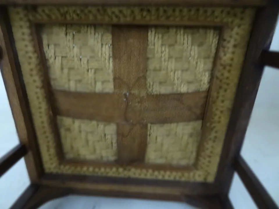 Sillón de escritorio antiguo con detalles decorativos, fondo claro.