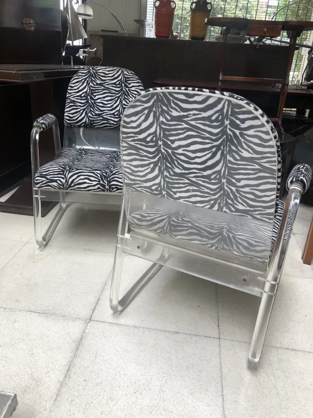 2 fauteuils anciens avec un design zèbre frappant, dans un cadre accueillant.