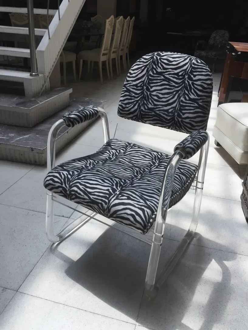 antiguos 2 sillones en forma de U con estampado de cebra en un ambiente.