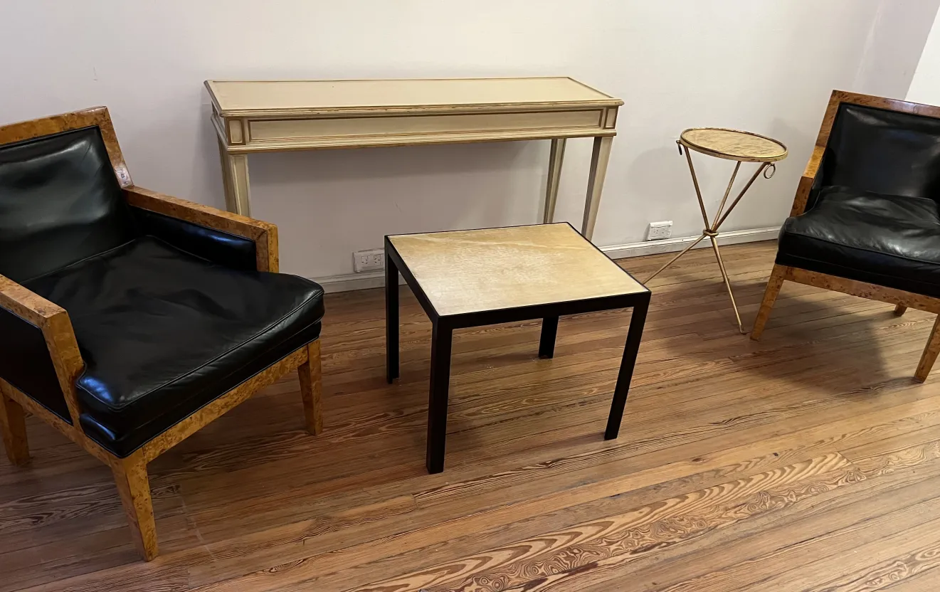 duas poltronas antiguas com assentos pretos em um quarto com móveis clássicos