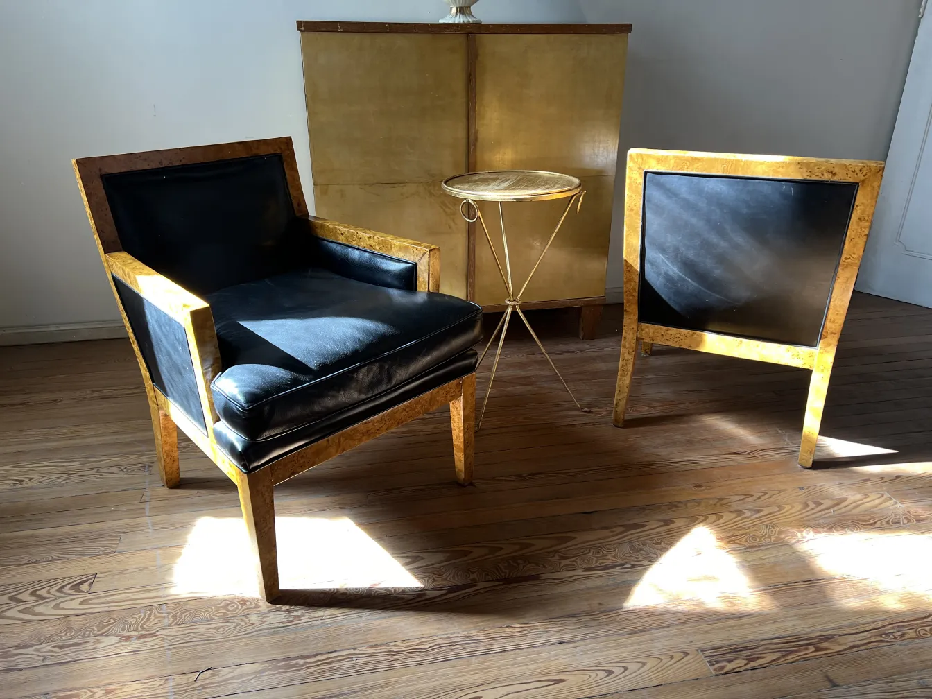 Deux fauteuils anciens au design élégant dans une pièce lumineuse.
