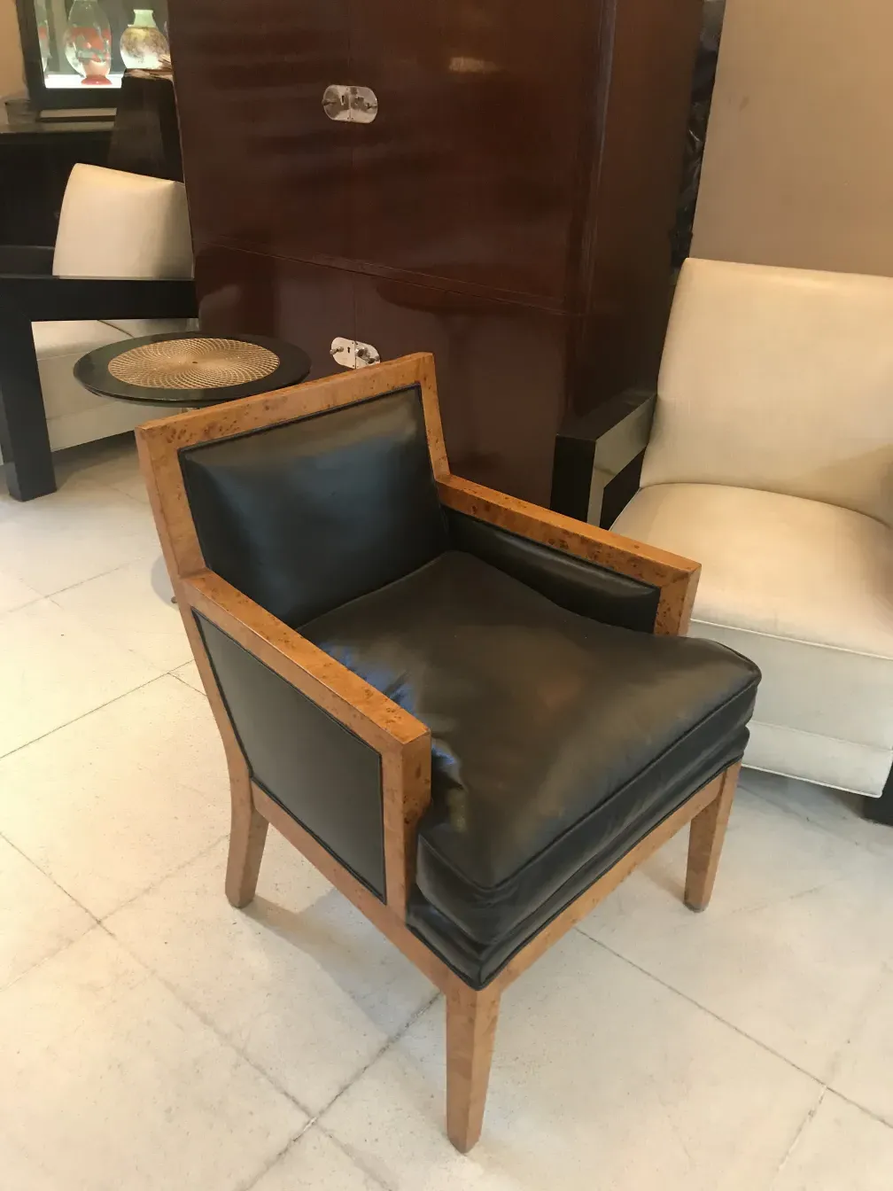 Two antique armchairs with a classic style, one black and one white in an elegant setting.
