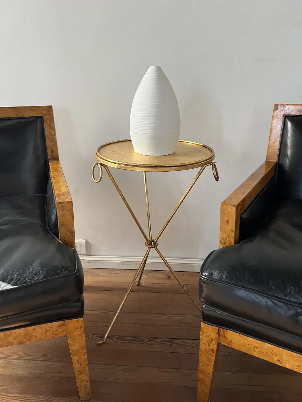 dos sillones antiguos de Jean Michel Frank, cuero negro, en un ambiente simple