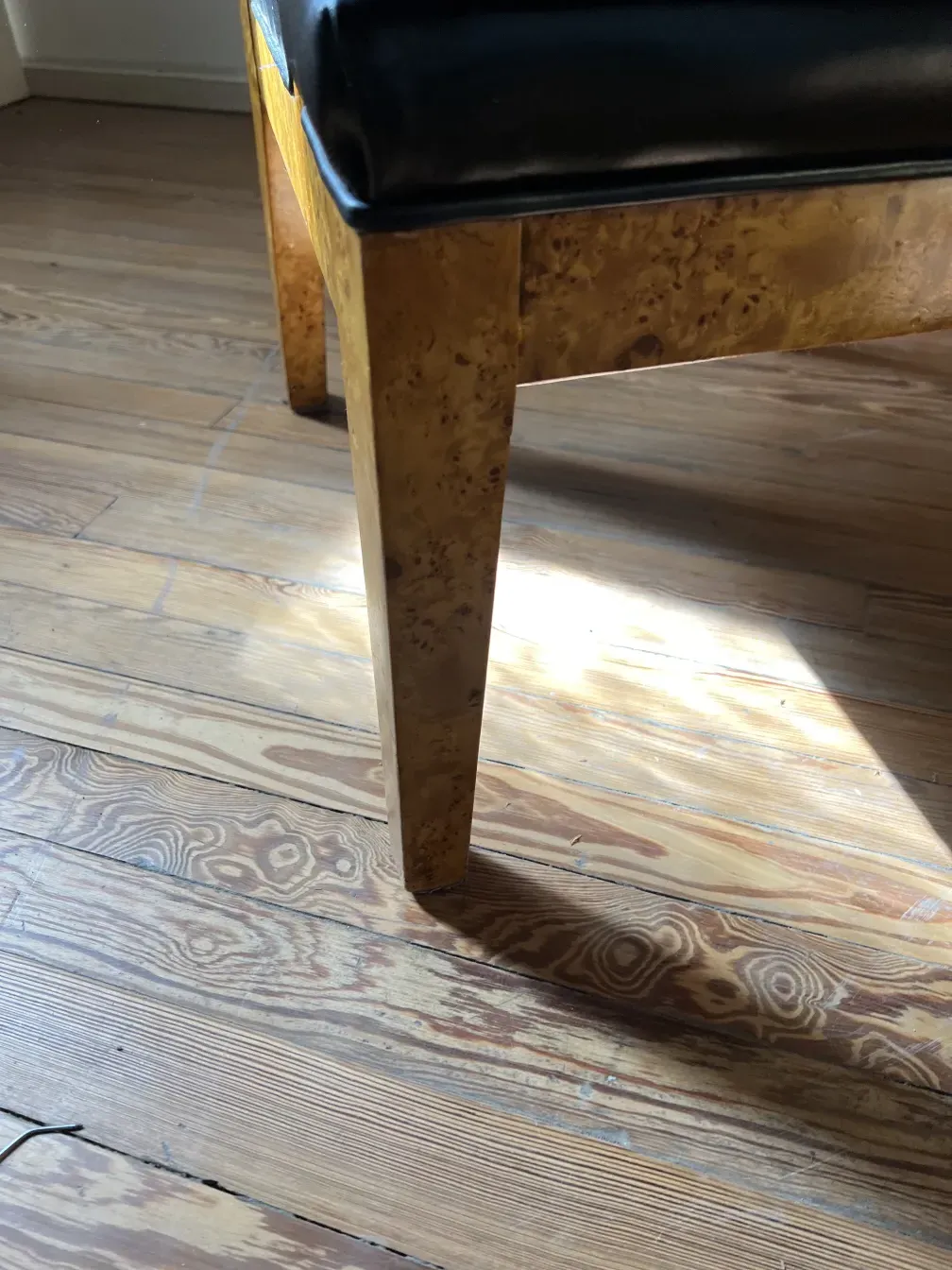 View of an antique armchair with visible design in a warm setting