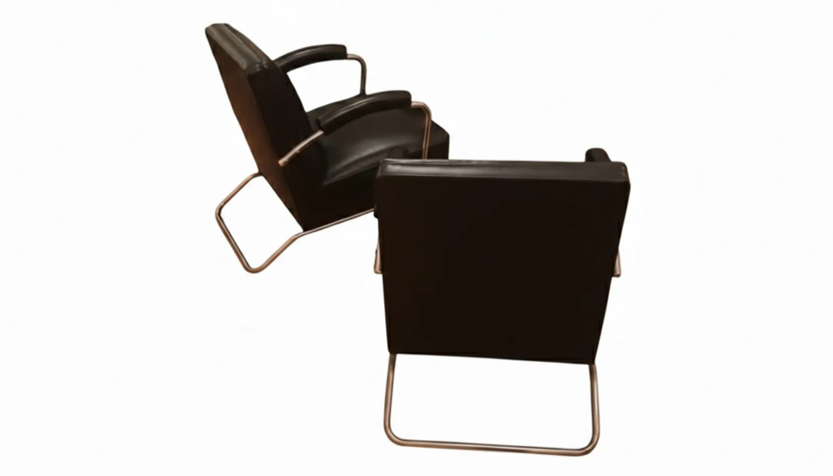 Vista trasera de dos sillones antiguos con líneas elegantes en un ambiente minimalista.