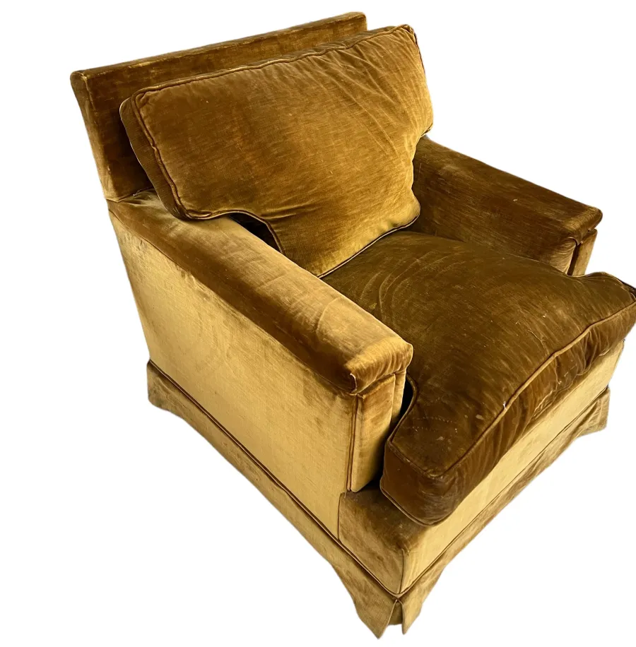 View of two antique yellow armchairs, one with extra cushions. Cozy setting.