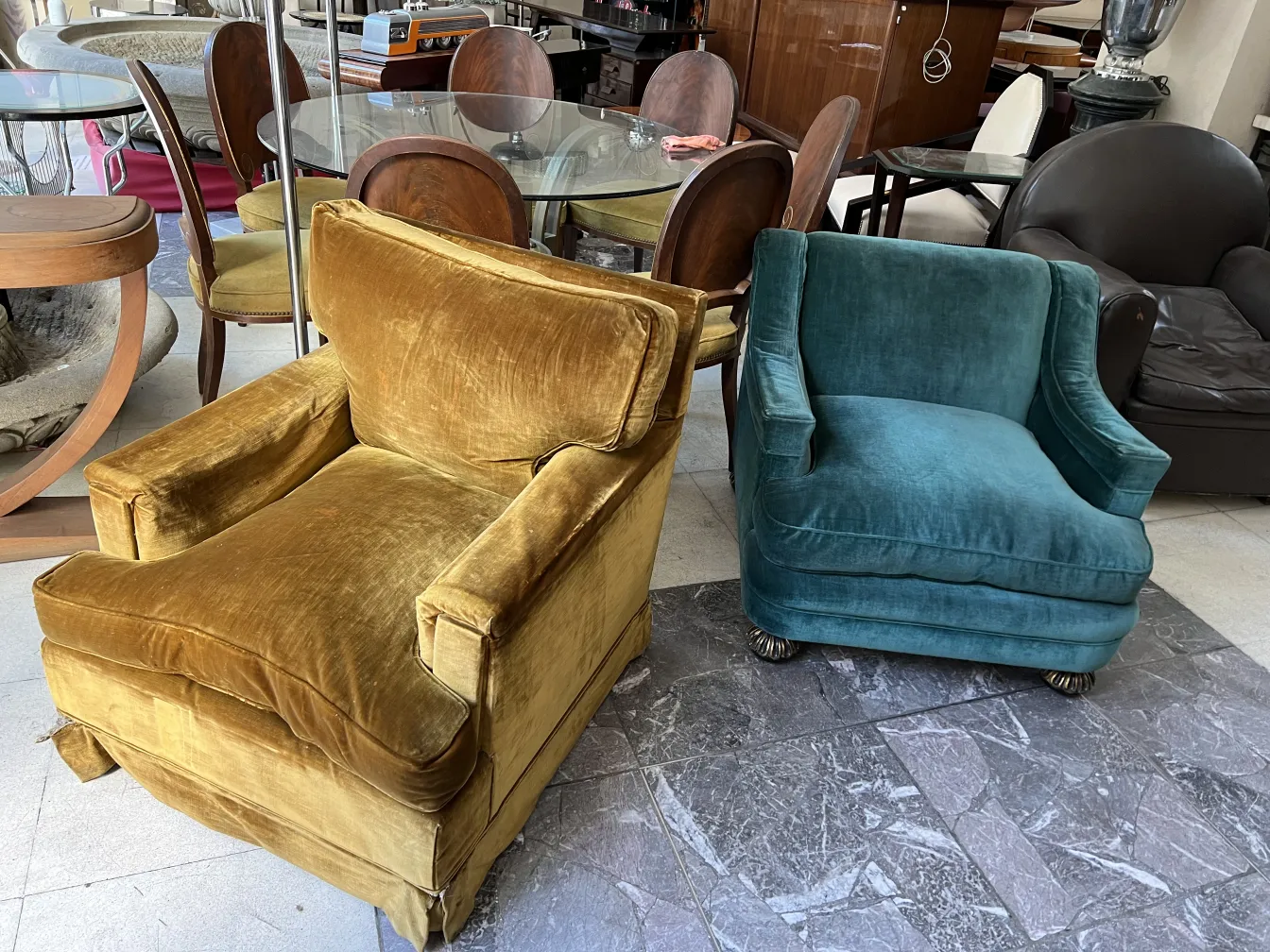 two antique armchairs in different colors in a room with a glass table, warm atmosphere.