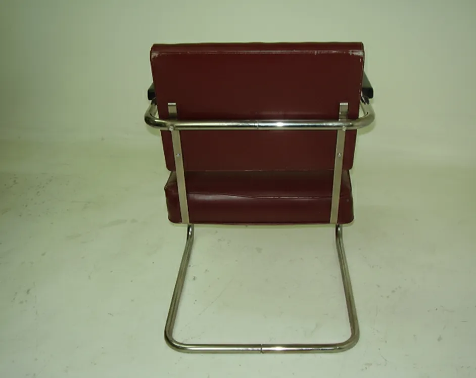 Vue arrière de deux fauteuils anciens à restaurer dans un cadre neutre.