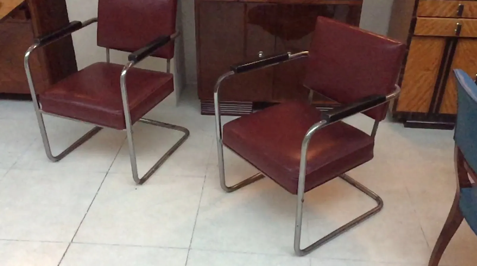 Dos sillones rojos con brazos en un ambiente vintage.