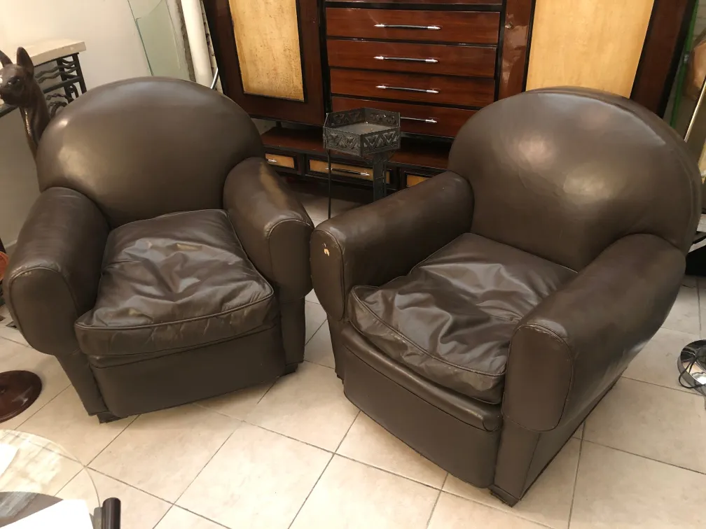 Duas poltronas antigas para serem restauradas, com design clássico em um ambiente acolhedor.