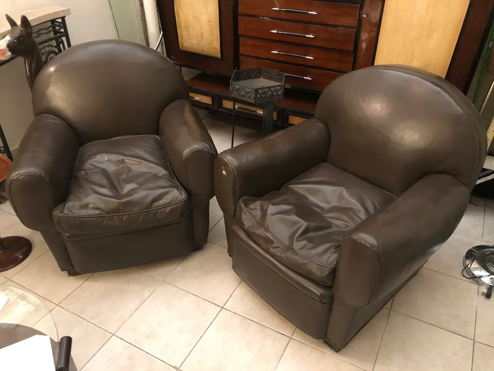 Deux fauteuils anciens au design arrondi dans un cadre élégant.