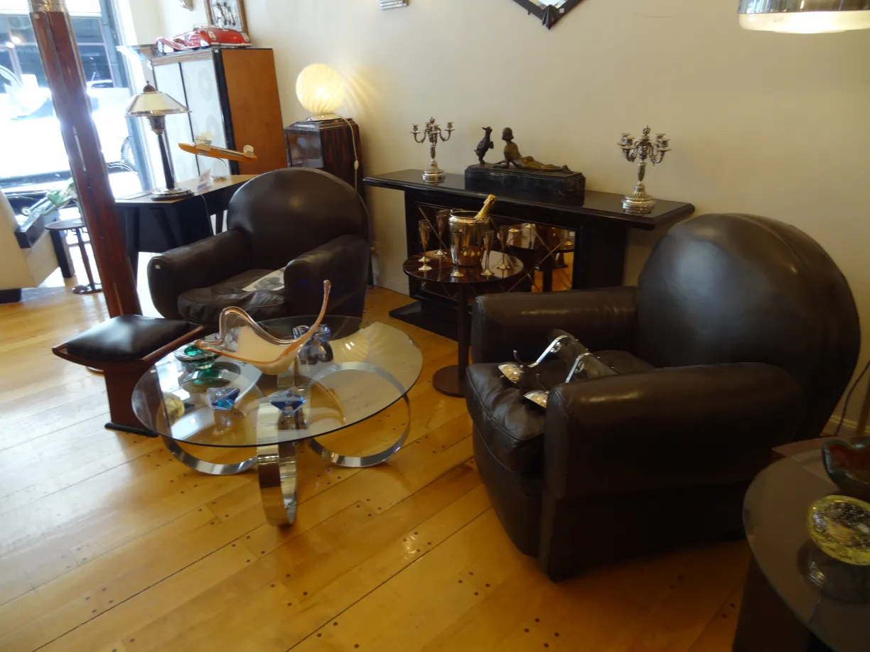 dos sillones antiguos en un ambiente decorativo con mesa y objetos