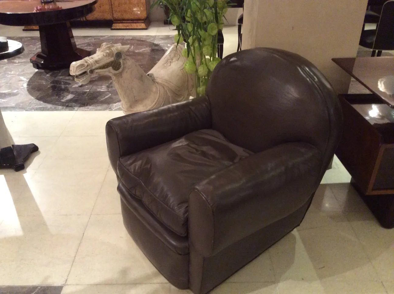 Dos sillones antiguos con un diseño clásico, necesitan restauración. En el fondo, se puede ver un caballo decorativo.