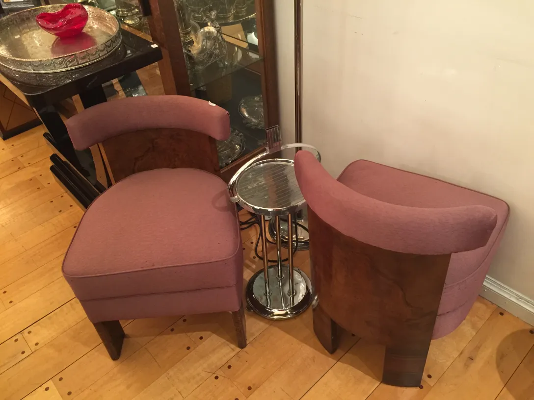 duas poltronas antigas em rosa, uma com uma pequena mesa