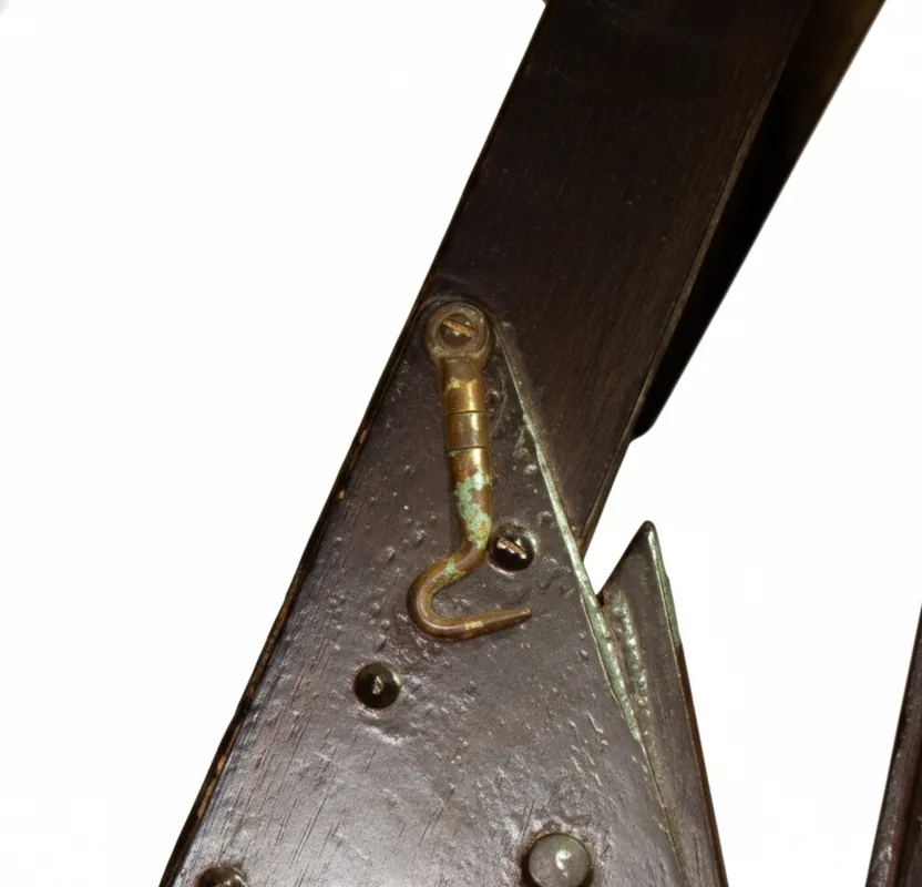 Detalhe de um mecanismo antigo em poltronas para serem restauradas, com texturas rústicas e cor de madeira escura.