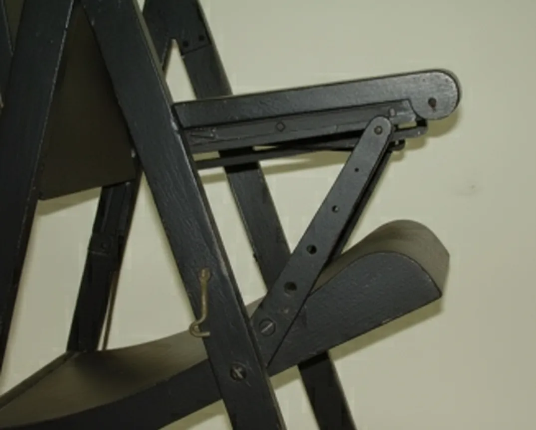 vista laterale di due poltrone antiche in un ambiente neutro con illuminazione soffusa.