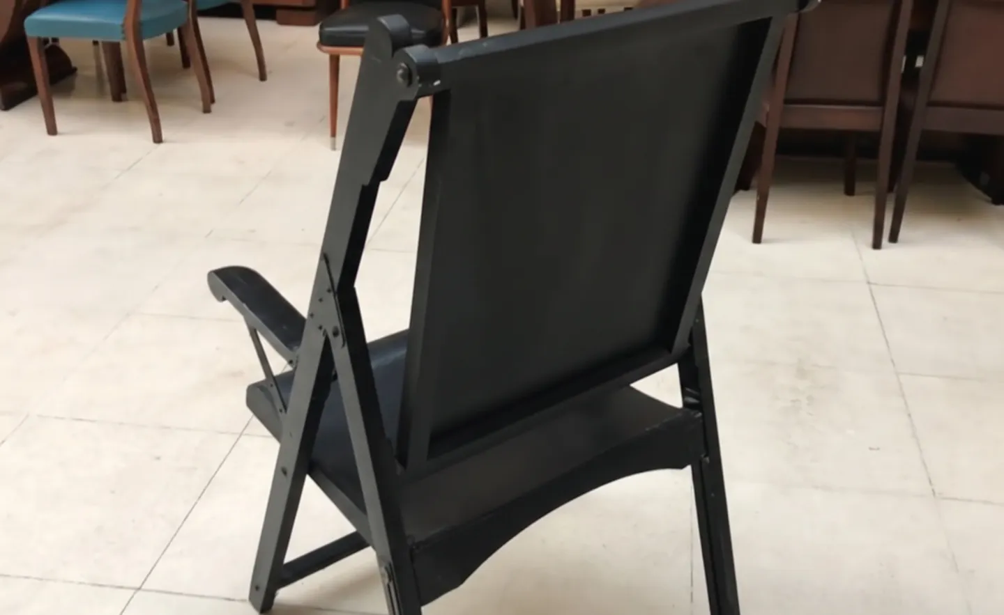 duas poltronas antigas em um ambiente de restauração, com cadeiras ao fundo