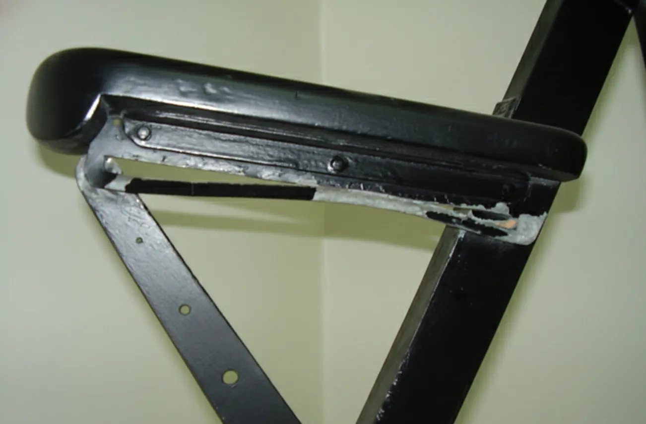 duas poltronas antigas com desgaste visível, em um ambiente neutro.