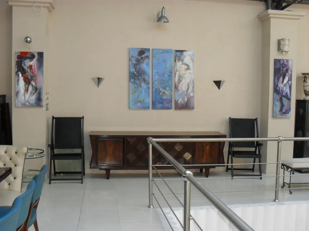 Due poltrone antiche da restaurare in un ambiente decorativo con arte moderna.