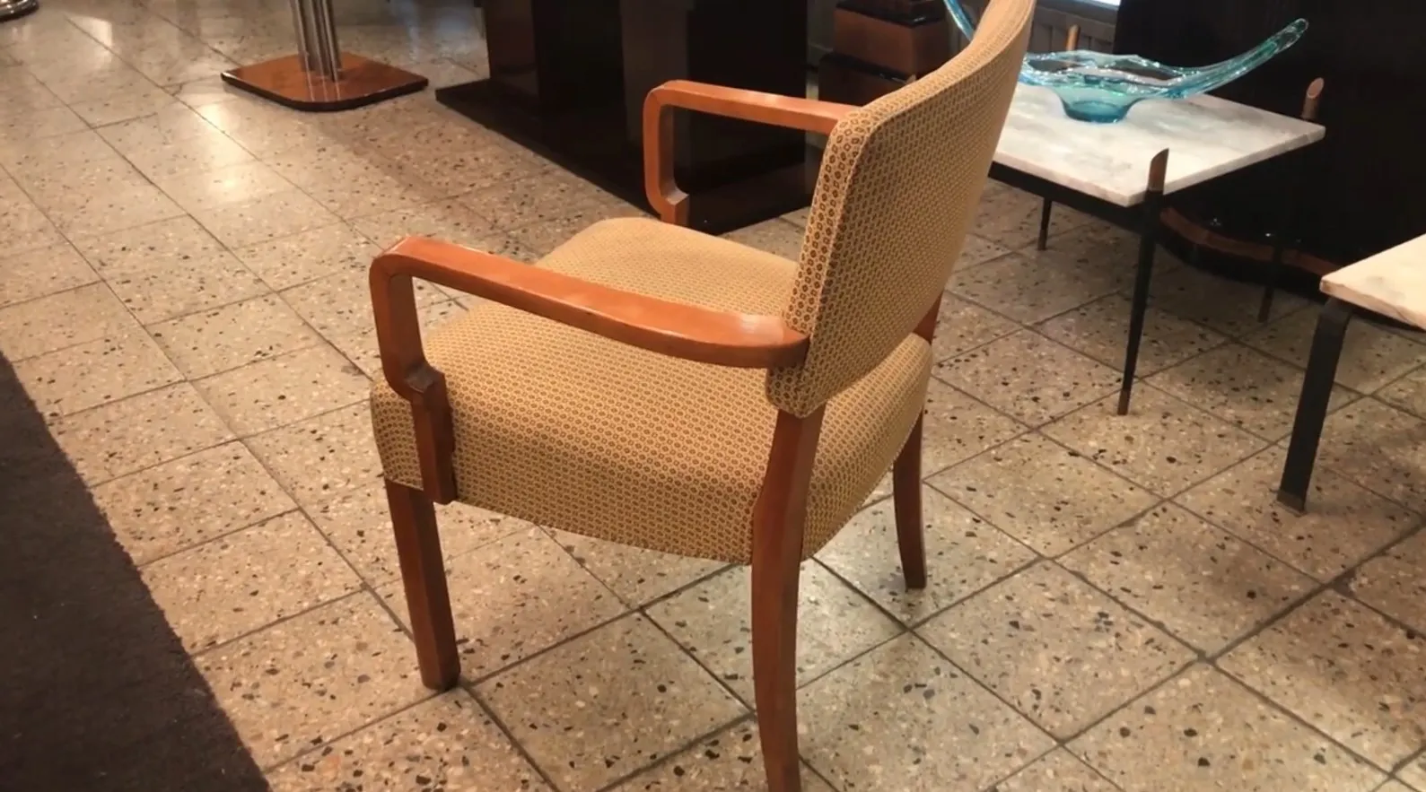 Sillón de escritorio antiguo con diseño ergonómico, color neutro, en un entorno de oficina elegante.