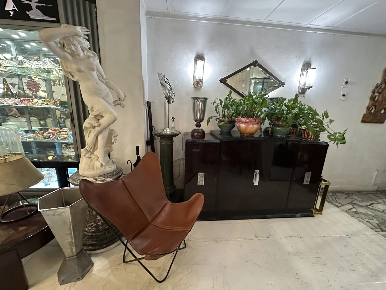 Poltrona antica BKF in un ambiente con statue e piante