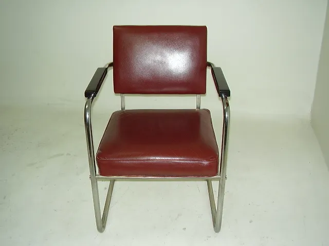Two antique armchairs, one with arms and brown upholstery, against a light background.