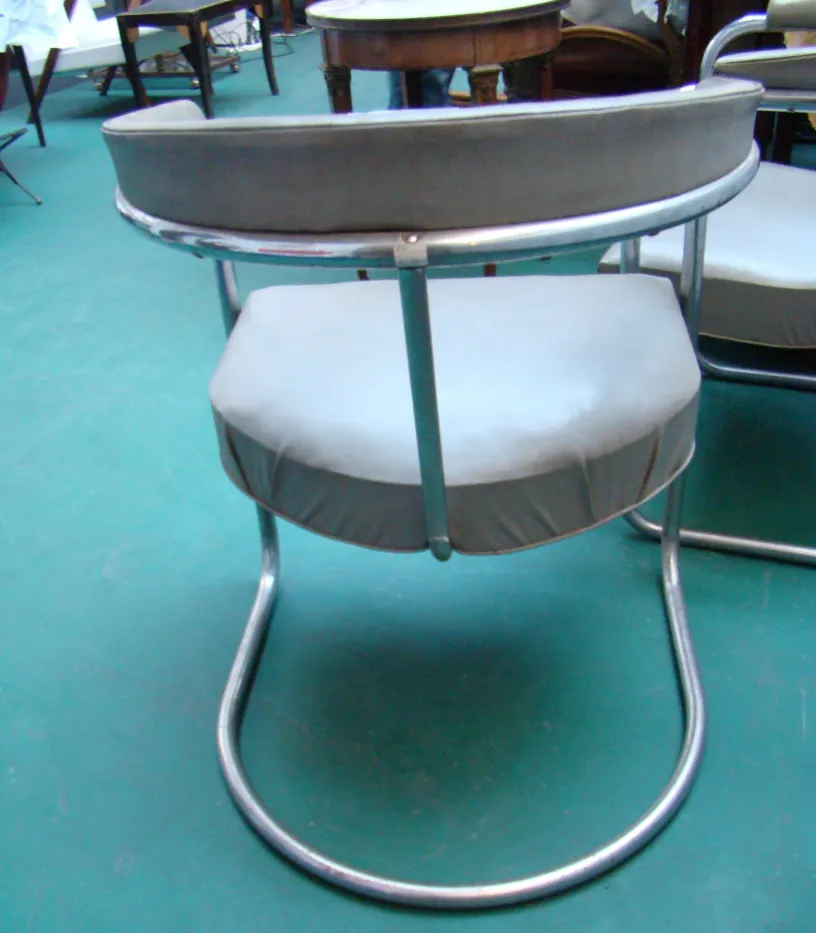 Vista de atrás de dos sillones antiguos para restaurar, ambiente de antigüedades.