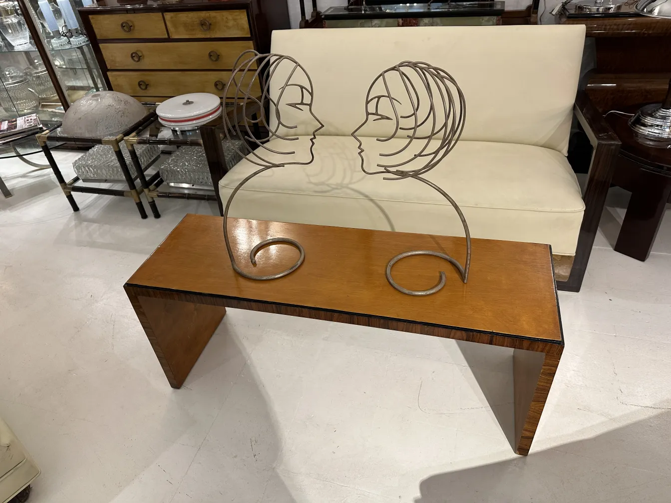 mesa de centro antiga com figura decorativa de perfil, em um ambiente clássico