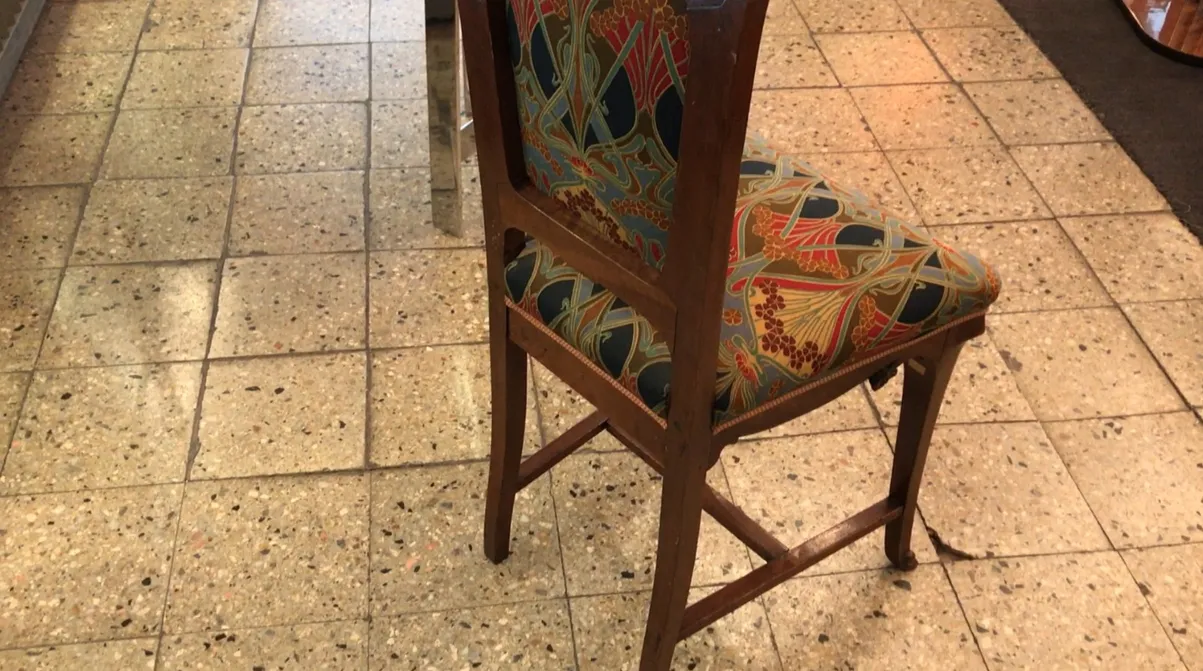 Silla antigua de diseño colorido en un ambiente moderno.