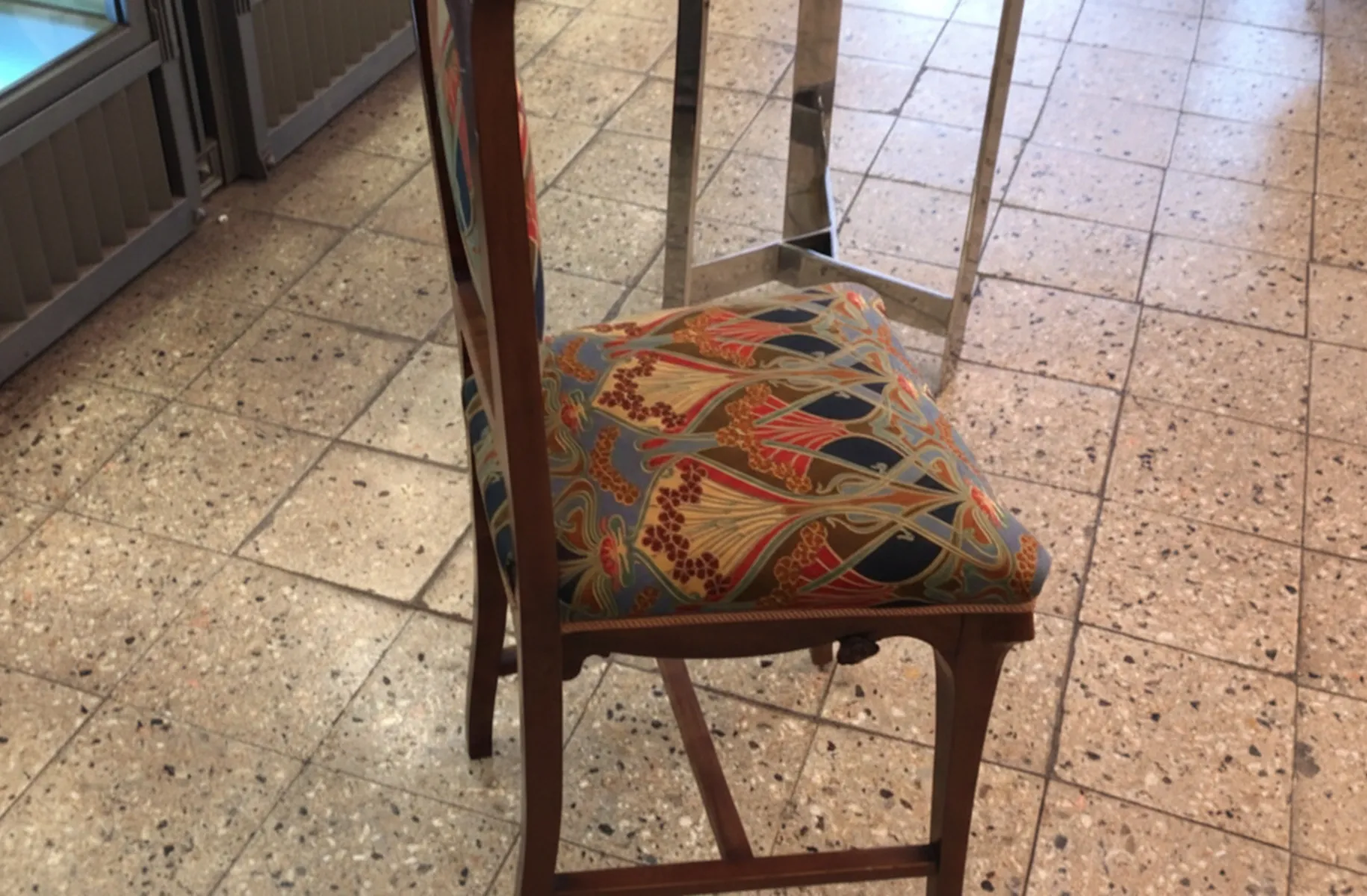Antique chair with a patterned cushion in Art Nouveau style.
