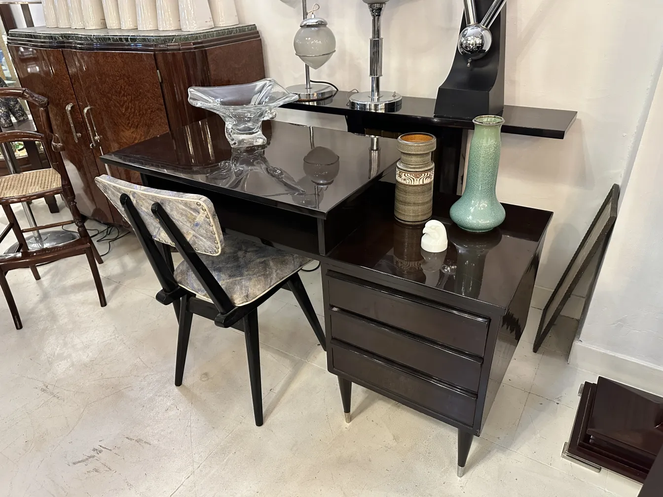 vista de dos sillas antiguas con un diseño exclusivo, en un entorno minimalista y elegante, rodeadas de otros objetos decorativos.