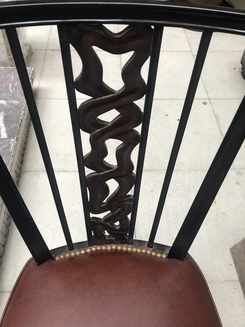 Side view of 2 antique chairs with artistic backrest and details