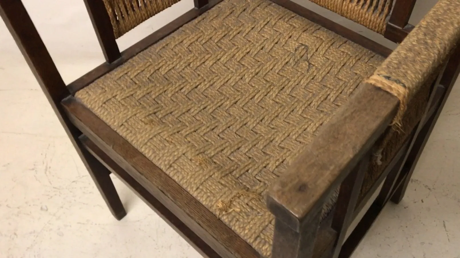 Antiker Bürosessel mit gewebtem Sitz in einer hellen Umgebung.