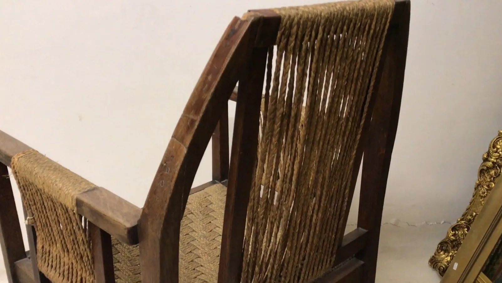 fauteuil de bureau ancien avec dossier en corde dans un cadre neutre